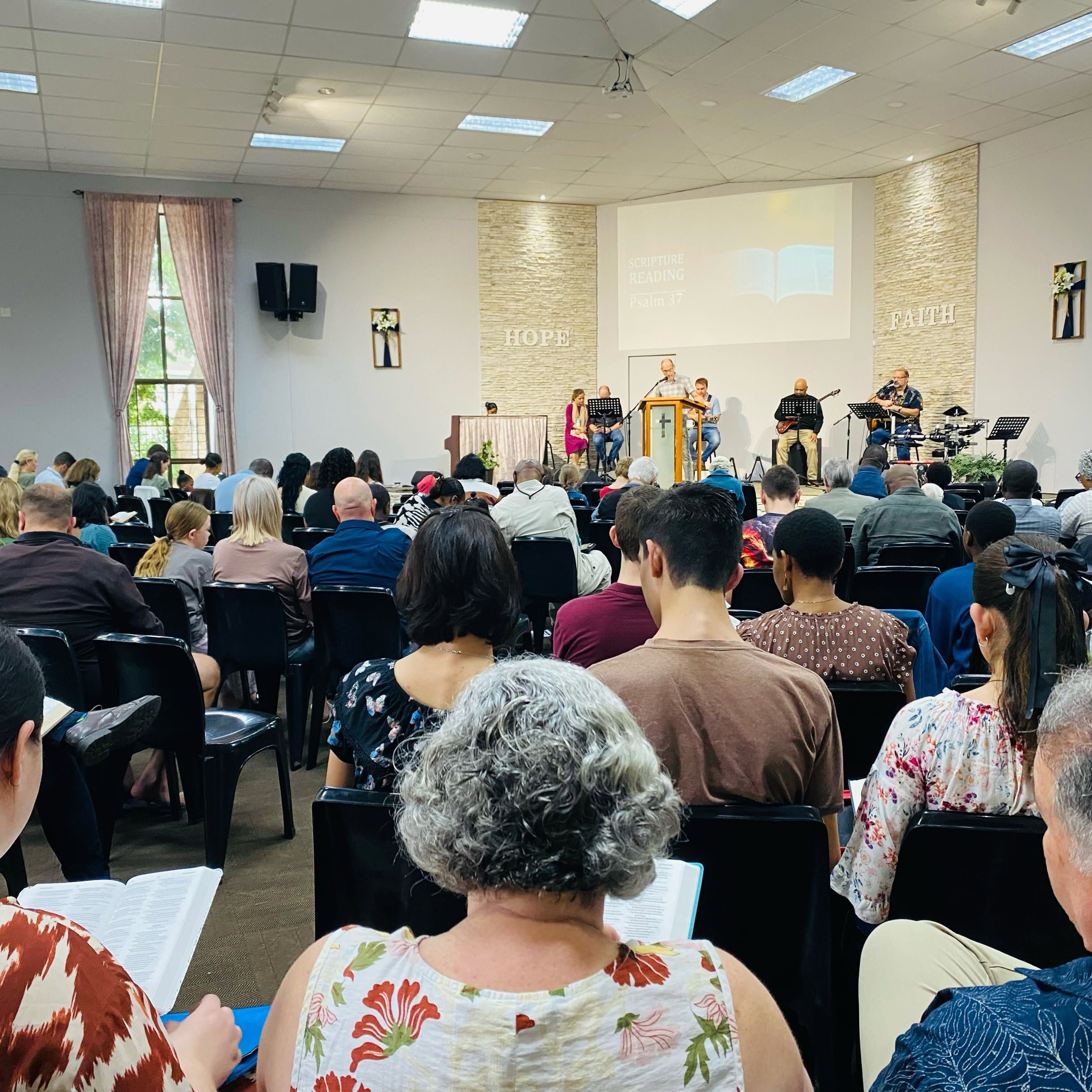 The congregation seated with Bibles open during a Scripture reading